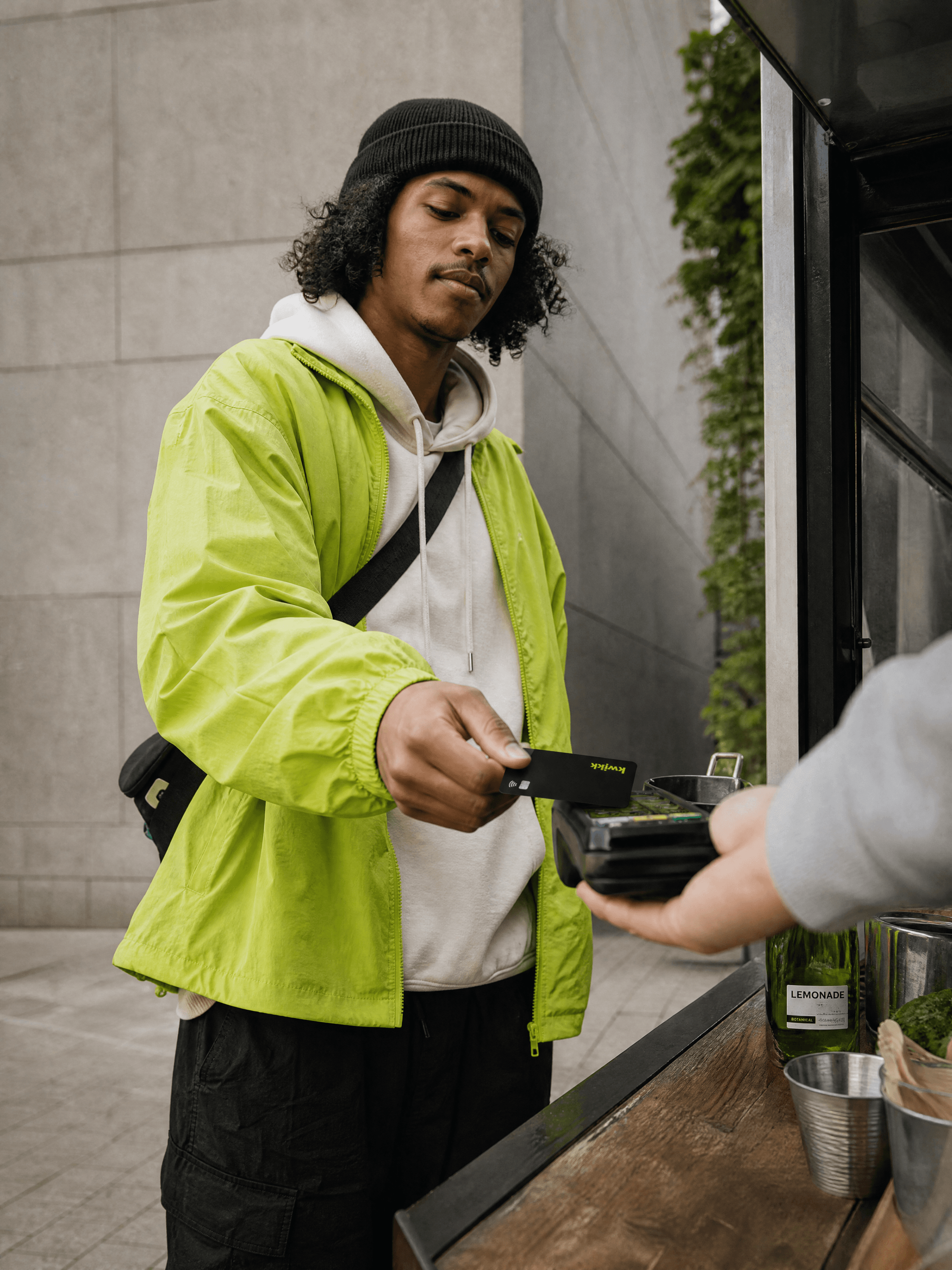 Jongen betaalt contactloos met zijn zwarte kwikk-kaart bij een straatkraam