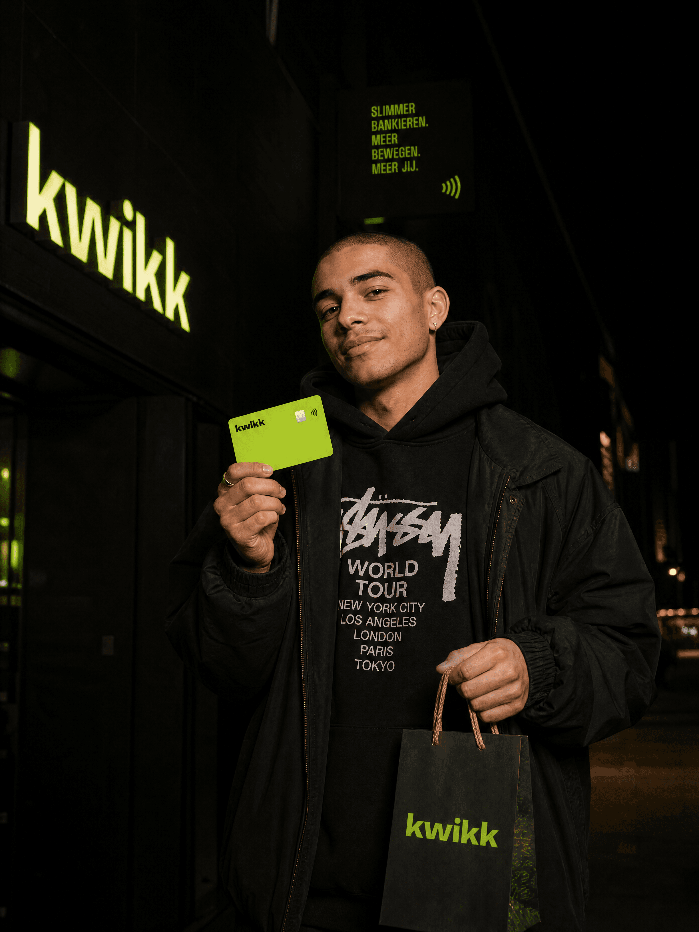 Jongen 's avonds voor een kwikk-winkel met zijn lime kaart en een kwikk-shopper